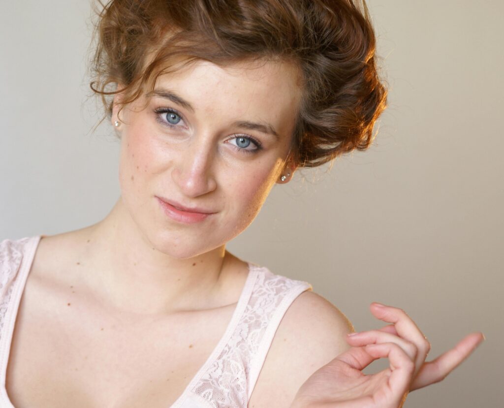 Charming portrait of a woman with styled hair, exuding elegance and grace in a studio setting.